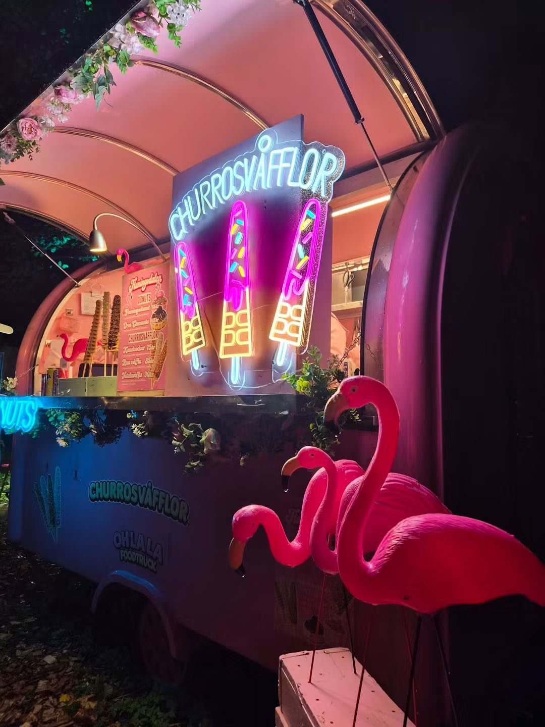 Churrosvagn med neonskylt och flamingos