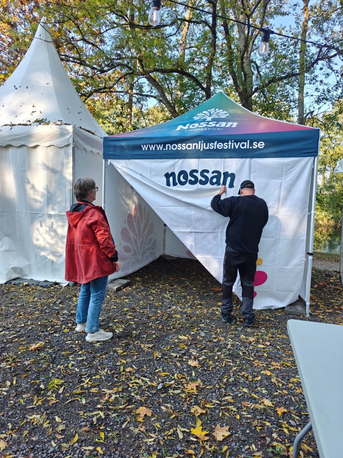 Volontärer klär festivaltältet med Nossan Ljusfestivals duk