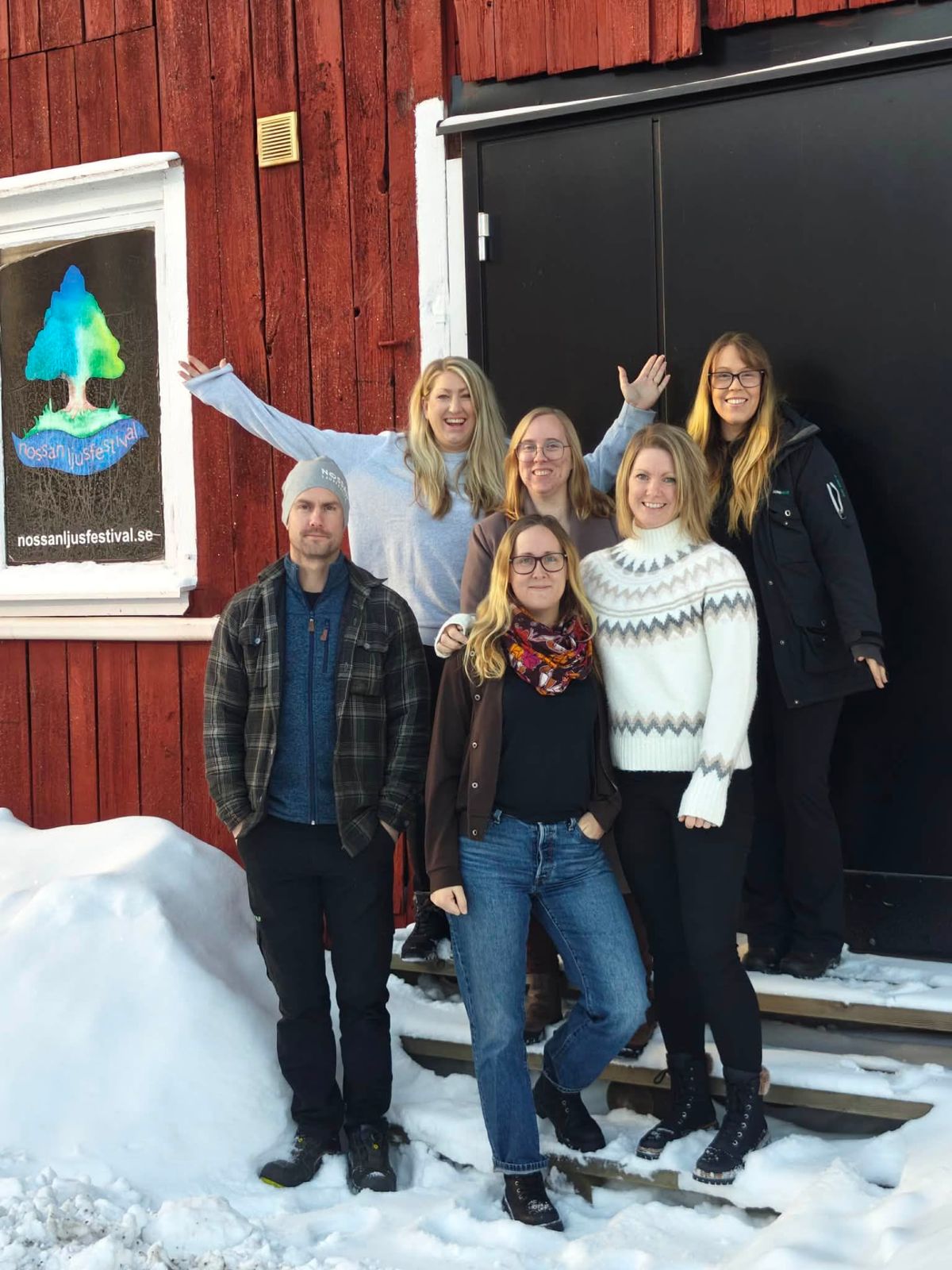Idégruppen samlad framför en röd lada i snön